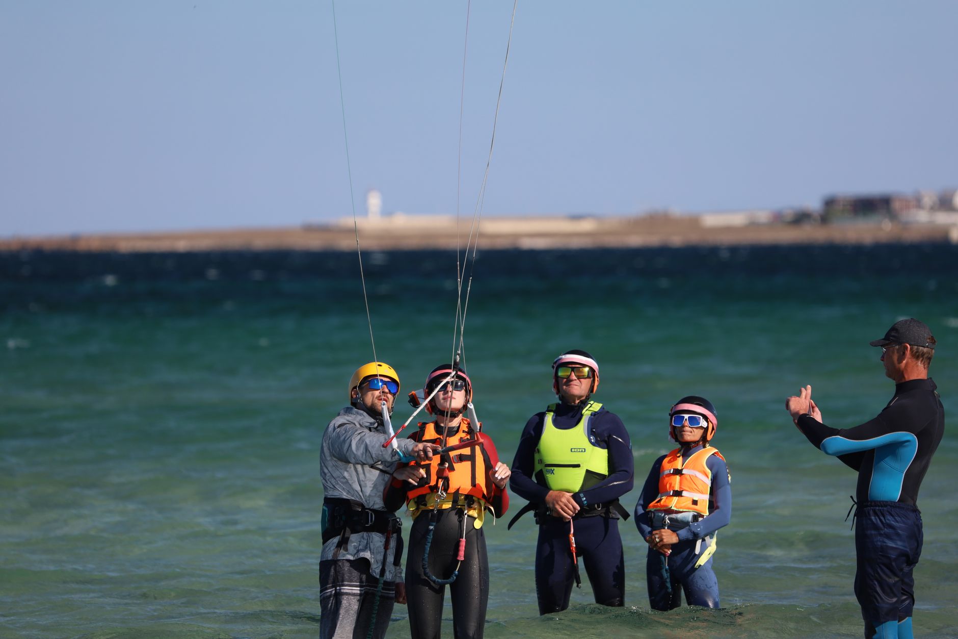 Grupo aprende kitesurf na praia