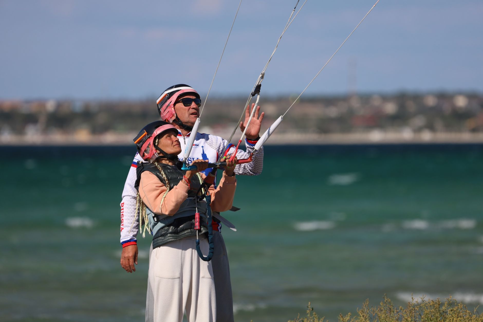 Instrutor ajuda a aprender kitesurf