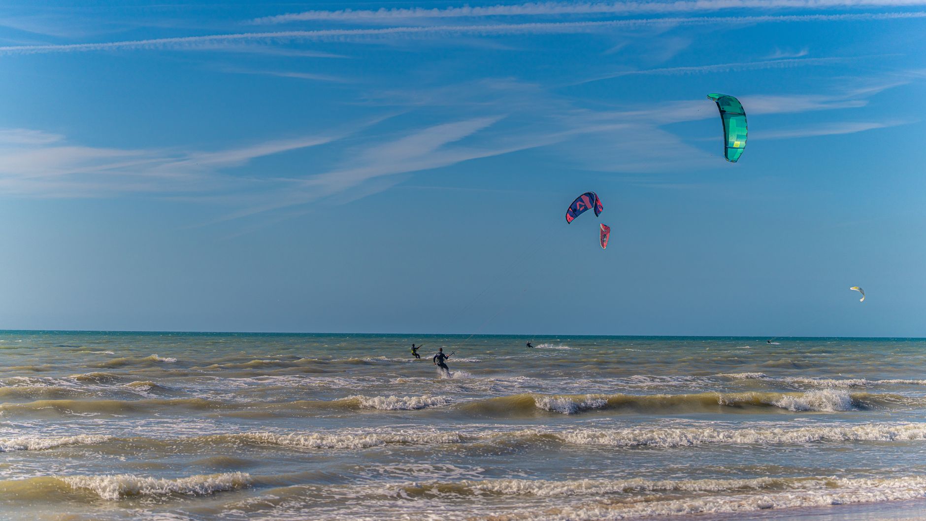 Kitesurfer auf dem Wasser vor der Kueste