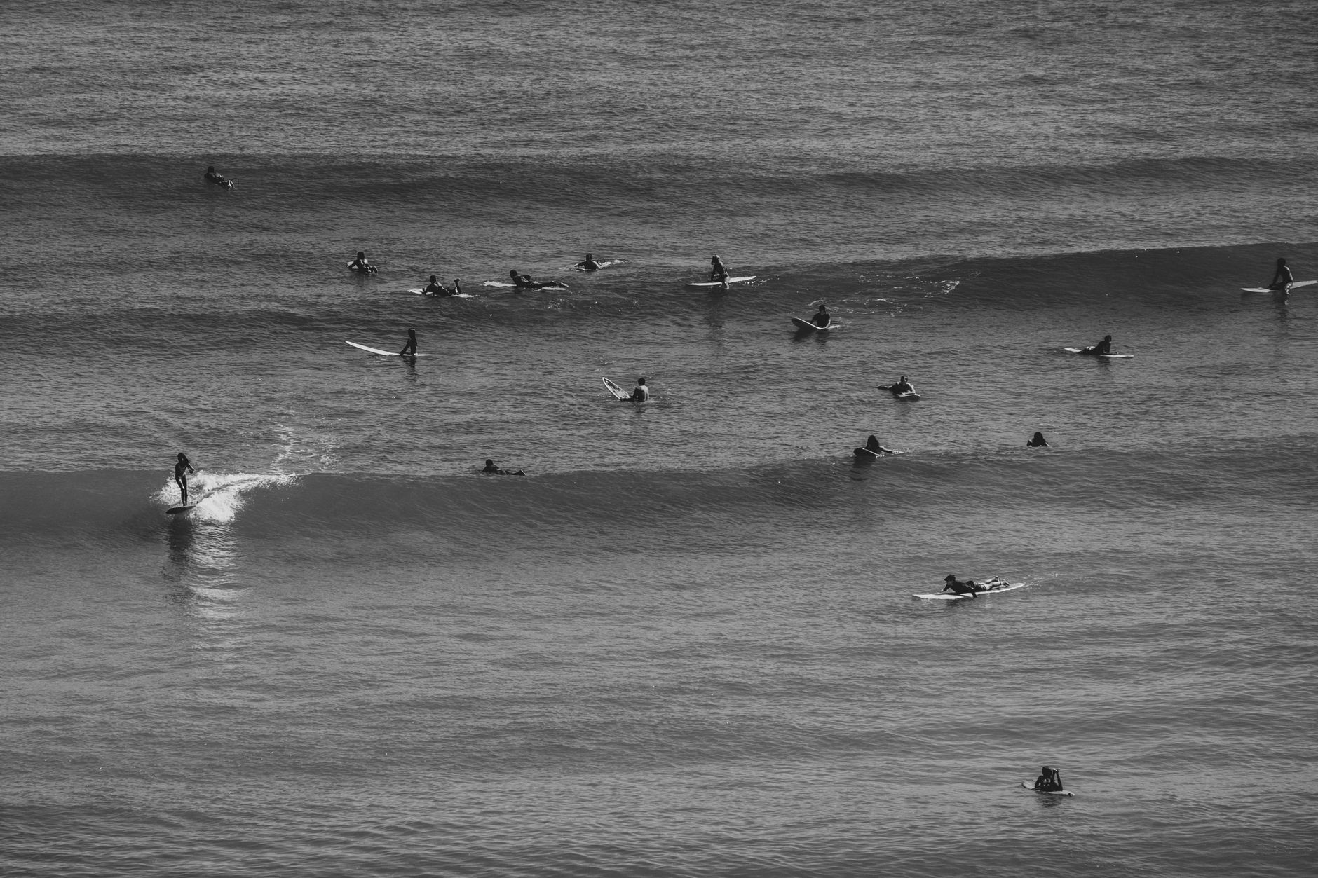 Surfistas esperan en el agua la próxima ola