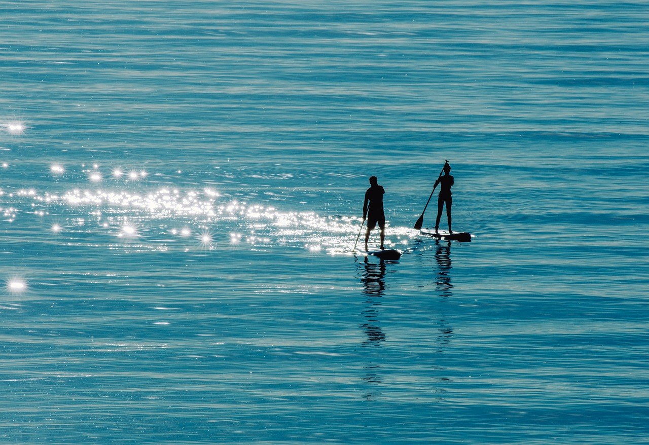 Zwei SUP-Paddler auf spiegelglattem Wasser bei Leichtwind