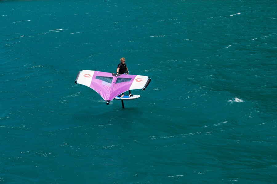 Wingfoiler gleitet bei wenig Wind über flaches Wasser
